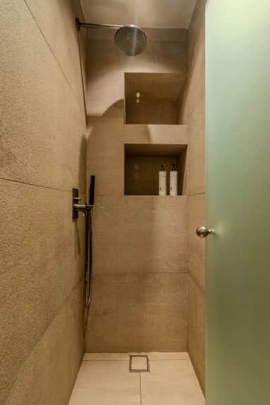 Junior Suite walk-in shower with a rain shower head, stone-look tiles and built-in niches