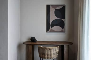 Wooden desk with a rattan chair under abstract artwork in the Superior Double Room