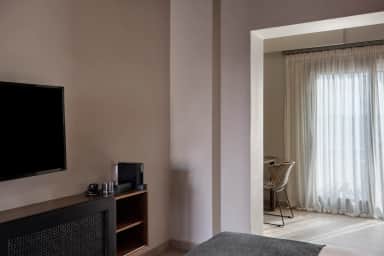 Superior Double Room with a wall TV, coffee machine and a sheer-curtained window nook