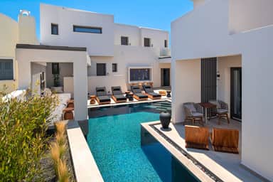 Superior Double by the Pool, the outdoor pool and sunbeds beside a terrace with two chairs and a table