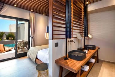 Superior Double by the Pool with twin basins on a wooden vanity and glass doors to a poolside terrace